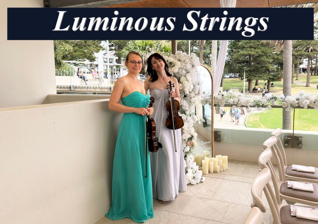 Two female musicians from Luminous Strings performing with a violin and cello at a bright outdoor event venue.