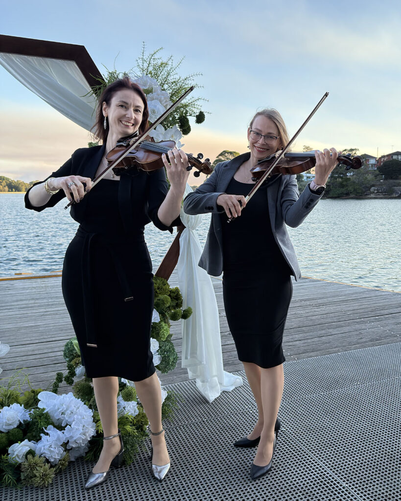 Two professional female violinists performing as a string duo for an event in Leichhardt, Sydney.