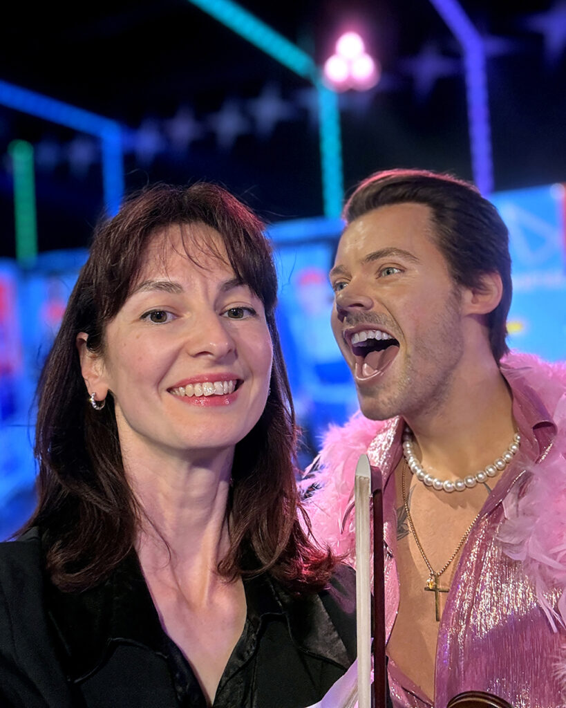 Live corporate event violinist posing next to the Harry Styles wax figure during a performance at Madame Tussauds Sydney.