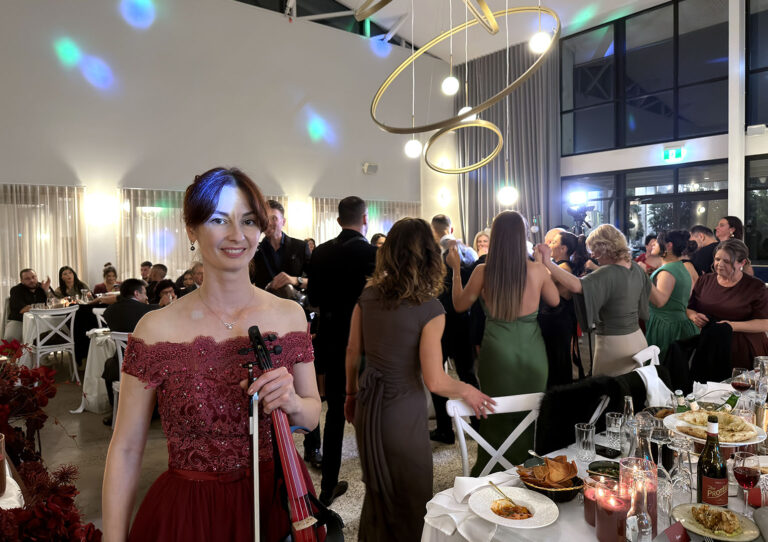 Live wedding violinist performing high-energy music for guests dancing at a reception party