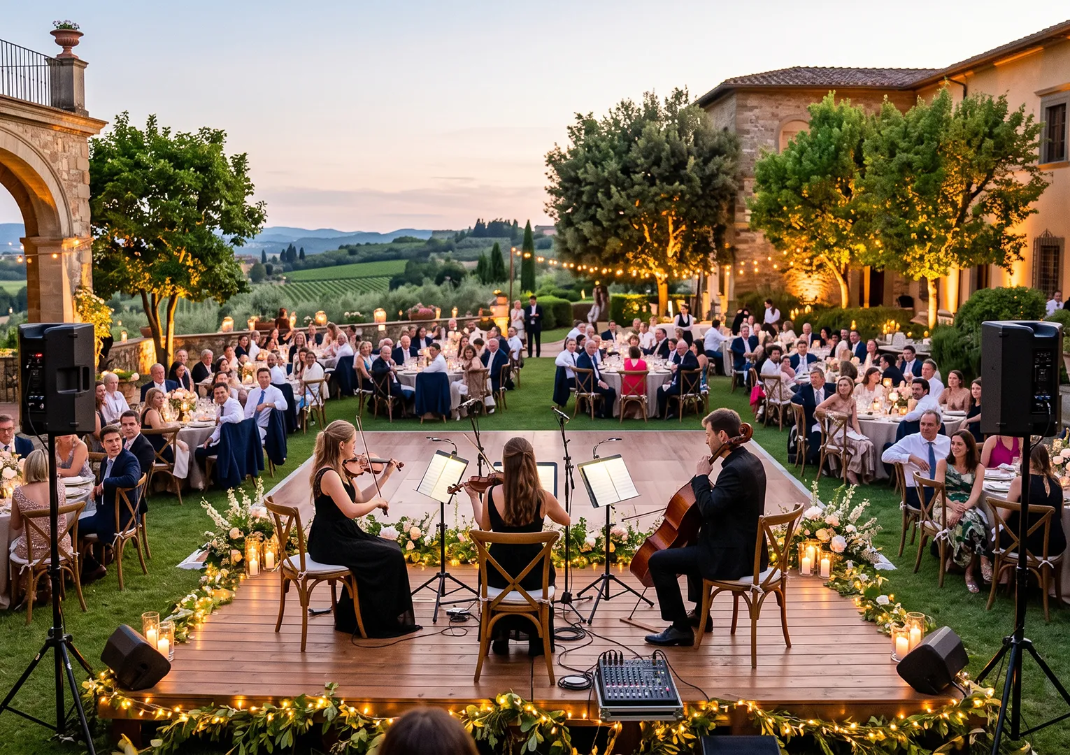 String ensemble performing live on an illuminated outdoor stage during a PlanEvent sunset wedding reception.